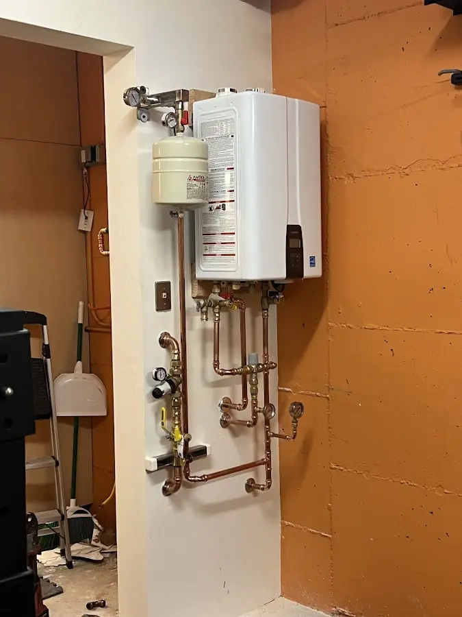 Plumbing technician inspecting water heater connections in Archdale